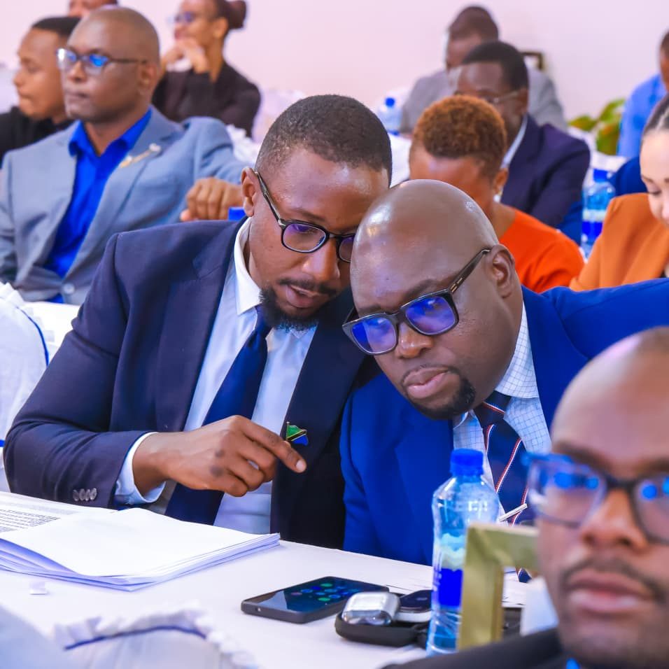 Junior Msangi in discussion with a fellow delegate at a conference